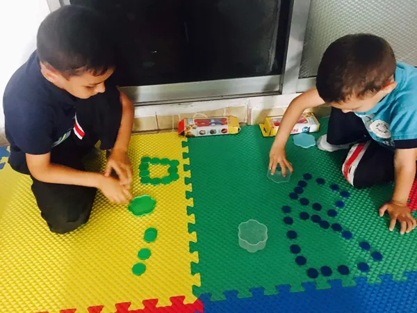 Niños agrupando fichas de colores sobre un tapete